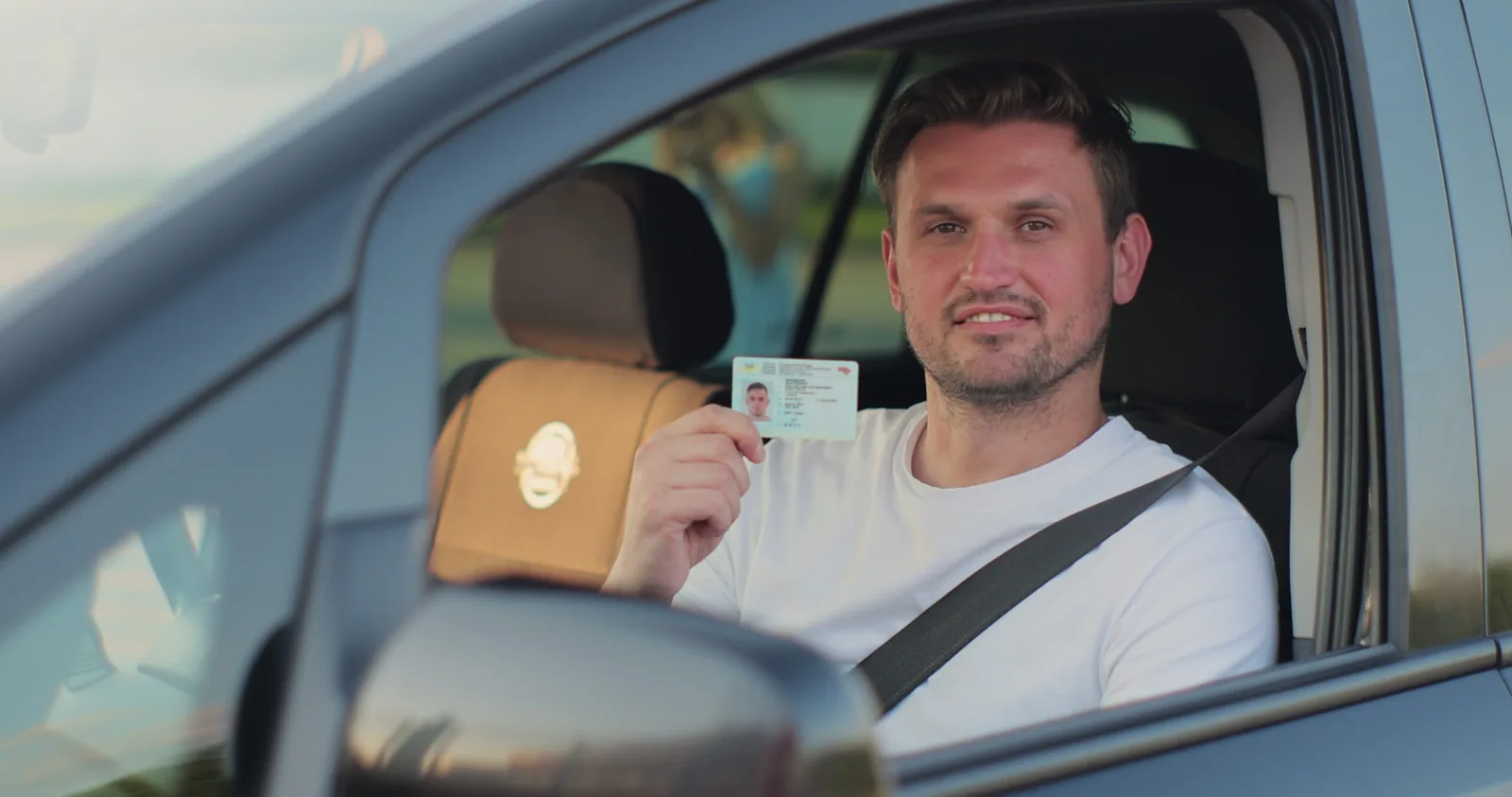 Conducteur souriant tenant un permis de conduire numérique Conducteur souriant tenant un permis de conduire numérique